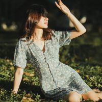 斗破苍穹库主编墨行舟的工作照：侧身坐在书架前翻阅手写笔记，桌上摊着贴满彩色便签的资料页，午后侧光落在纸面，氛围沉静专注